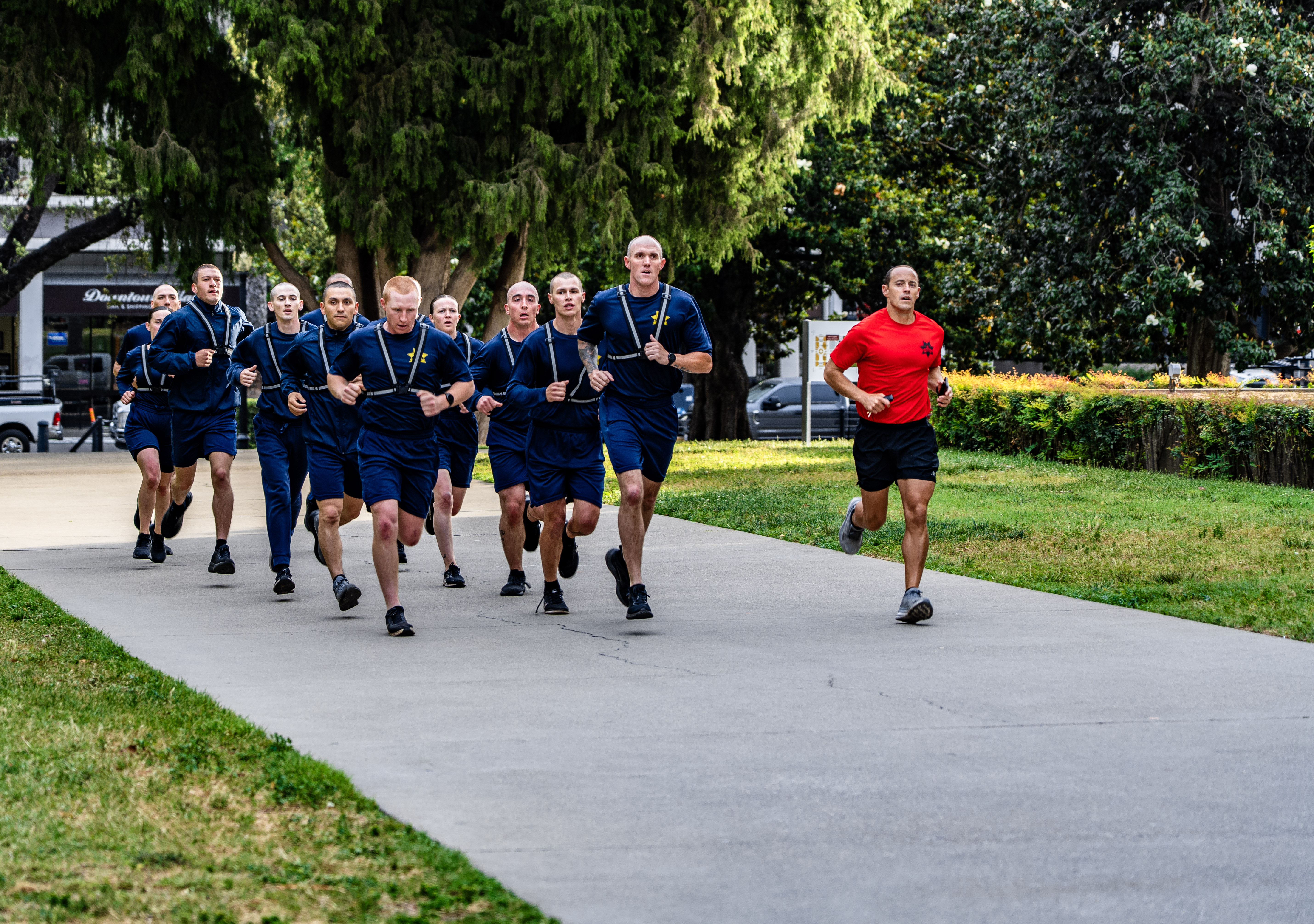 A photo of a group of Sacramento Police Department cadets running down a paved trail as part of their Academy physical training