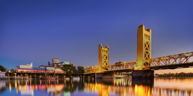 Sacramento Tower Bridge in the evening with lights reflecting from river.