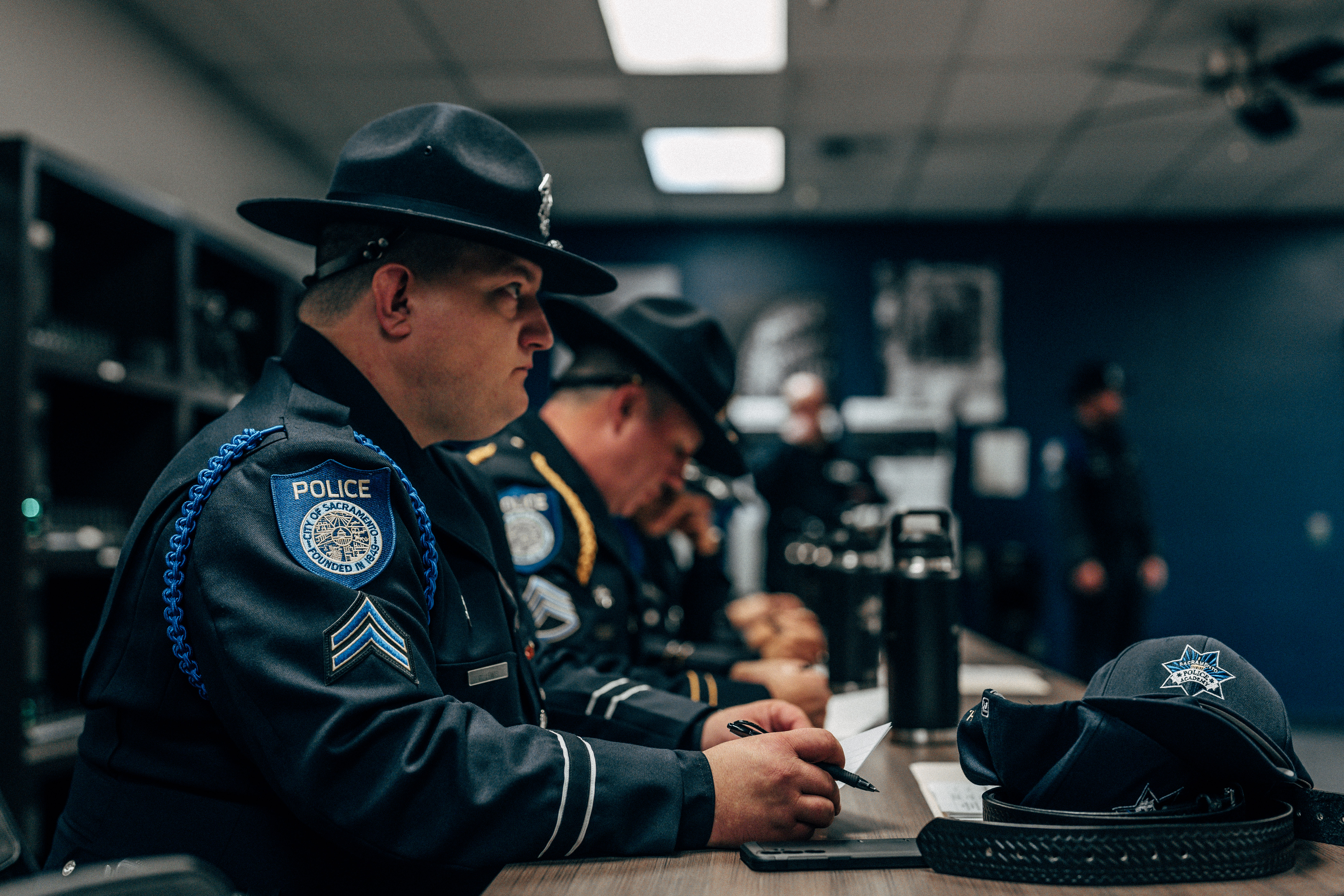 The photo shows academy corporals in full uniform sitting at a desk in an interview setting
